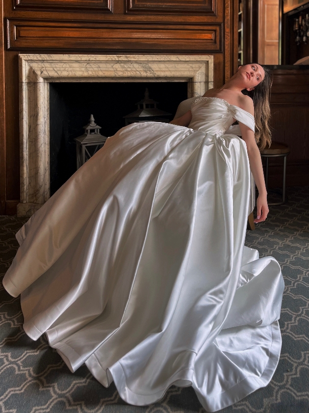 model in wedding dress draped over chair