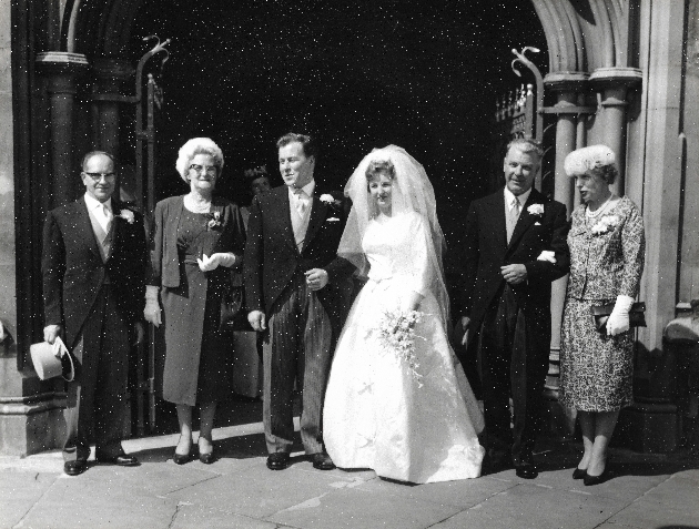 Old black and white picture of groom and bride outside church