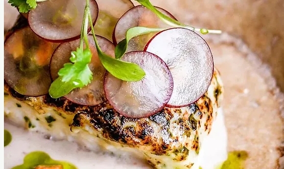 Close up of fillet fish with radish garnish