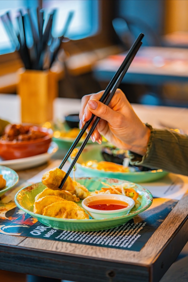 dumpling being dipped in dipping sauce