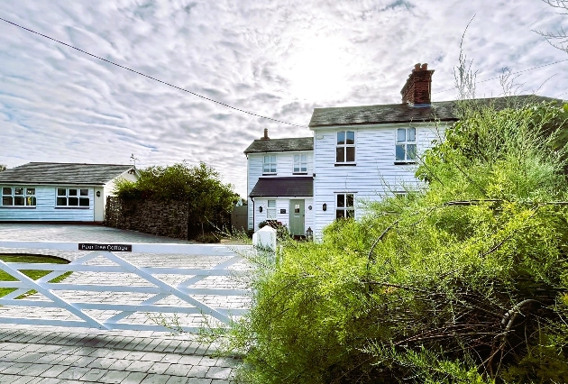 large white guest house with white gate