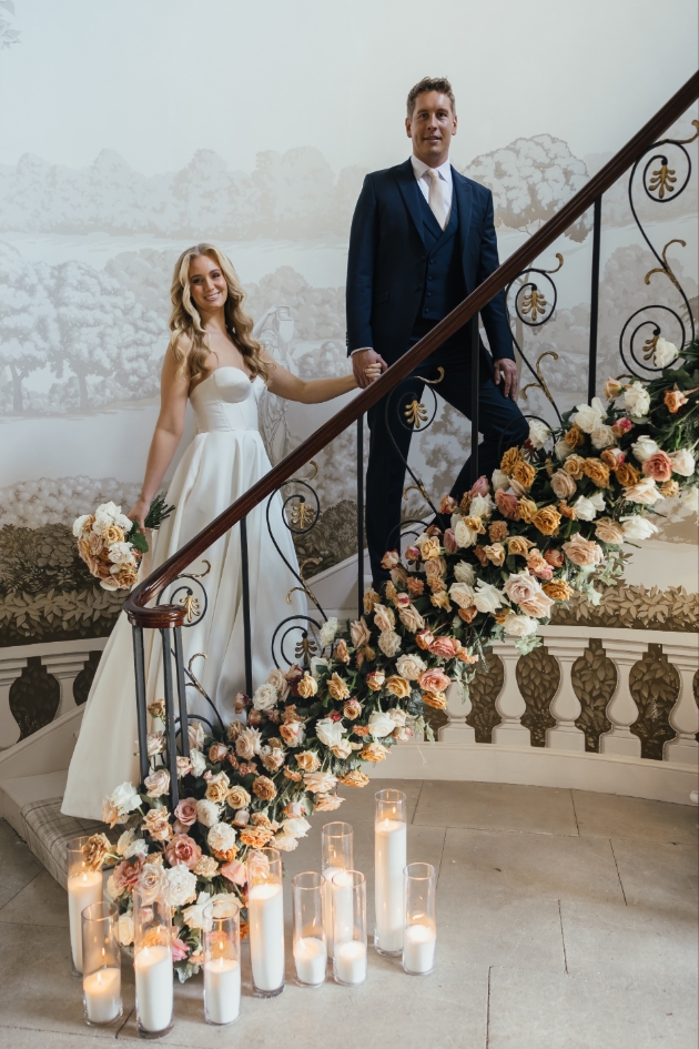 bride and groom walking up grand staircase