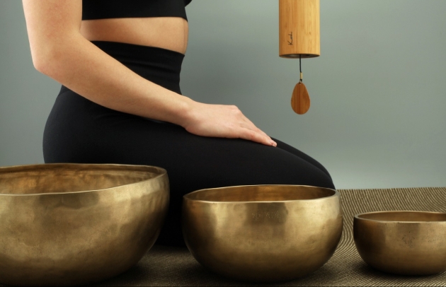 lady kneeling next to gong baths