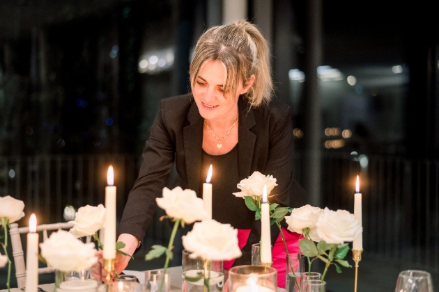 lady decorating table with candles and floral arrangements